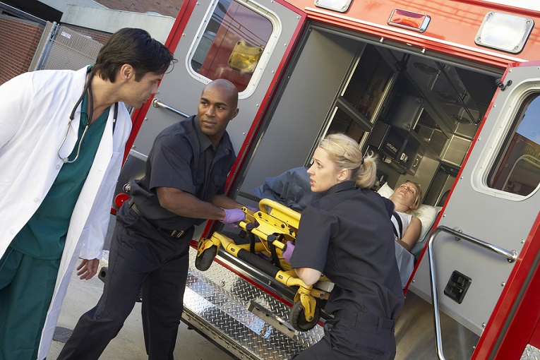 Paramedics and doctor unloading patient from ambulance, Apr 2020